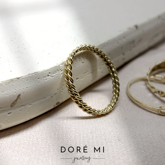 Experience understated elegance with our minimalist twisted 18K gold design ring. Delicately crafted, its subtle twist adds a touch of sophistication to your everyday style, making it the perfect accessory for effortless chic.